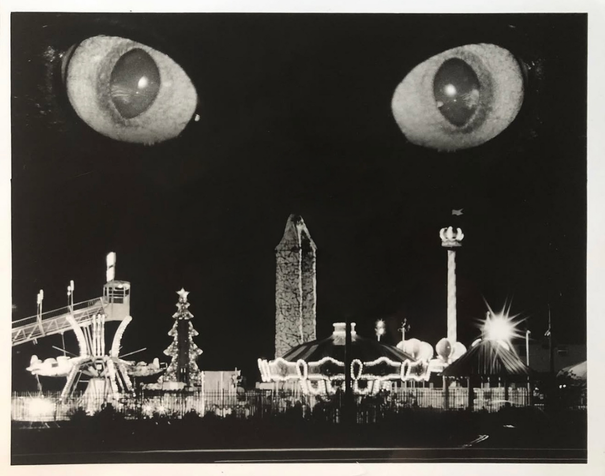 Surreal black-and-white film composite of a carnival scene with large cat eyes floating above, created in the darkroom during Lindsay Lee’s college photography studies