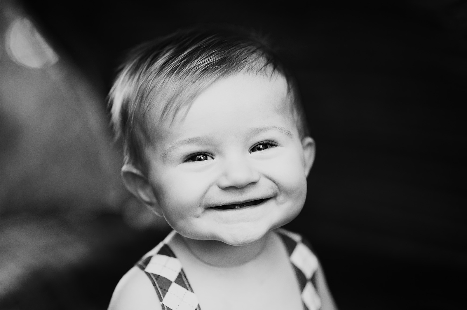 Smiling baby boy in black and white with soft light and joyful expression
