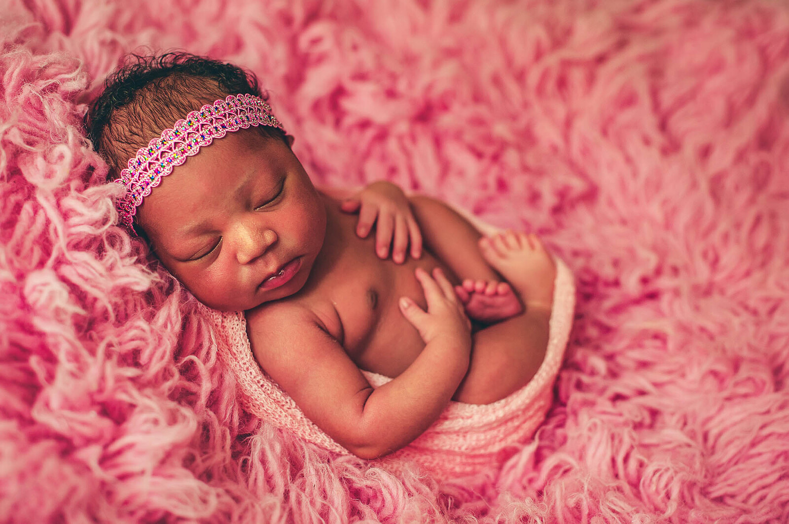Sarasota newborn photographer captures baby on textured pink fabric
